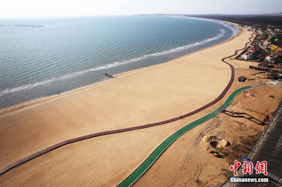 3月13日，秦皇島萬(wàn)米臨海沙灘木棧道。據(jù)了解，該木棧道全長(zhǎng)約4200米，與北戴河區(qū)原有的7500米木棧道對(duì)接后全線總長(zhǎng)度1.17萬(wàn)米，整個(gè)木棧道東起秦皇島體育基地游船碼頭，西至北戴河濕地公園，呈波浪形蜿蜒10.4公里海岸線。 中新社發(fā) 曹建雄 攝 CNSPHOTO